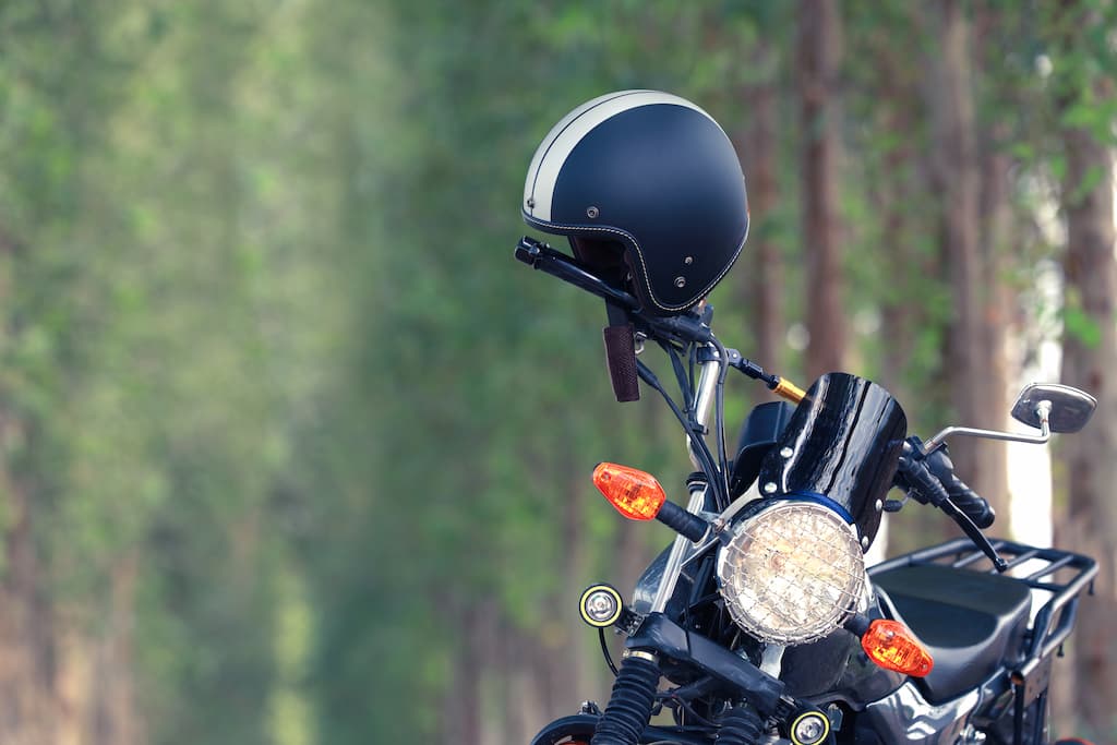 Na imagem há uma moto com o capacete apoiado.