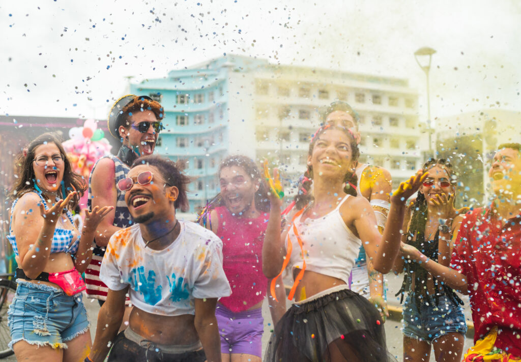 Na imagem há um grupo de pessoas diverso aproveitando o carnaval.